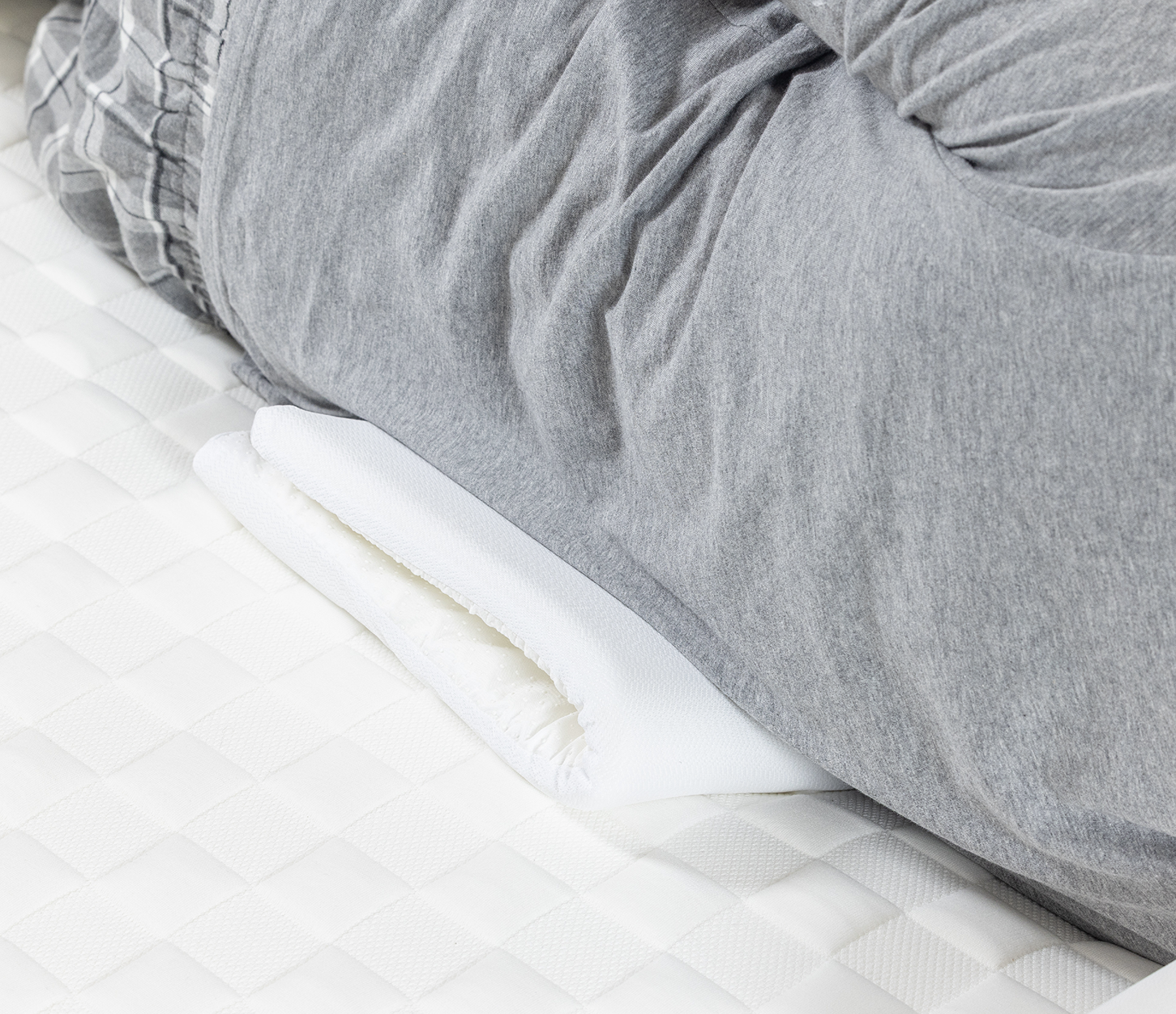 Folded up slice under a person at the trunk of the body to support and firm up mattress