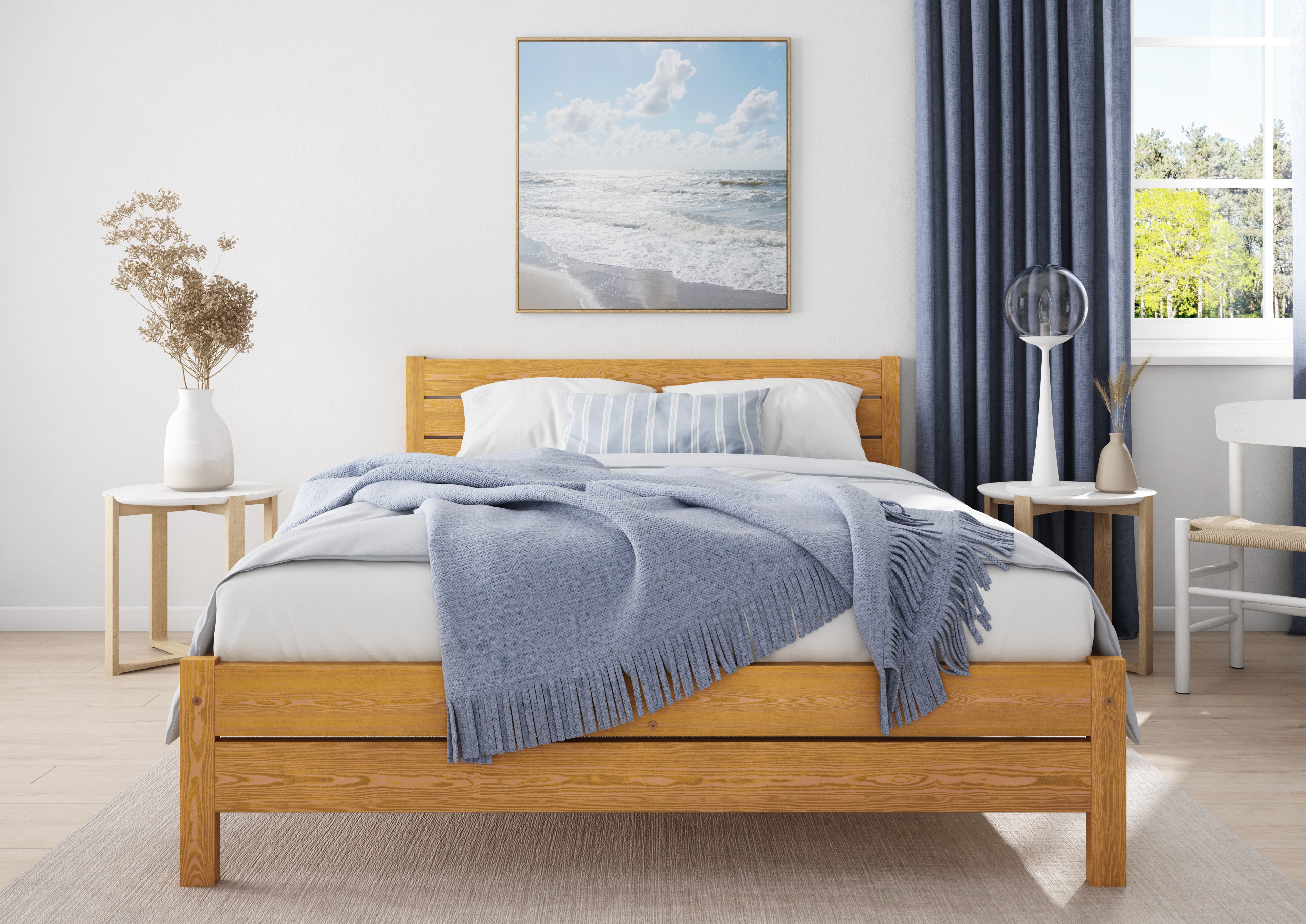 Wooden bed with white bedding and blue blanket in a bedroom setting.
