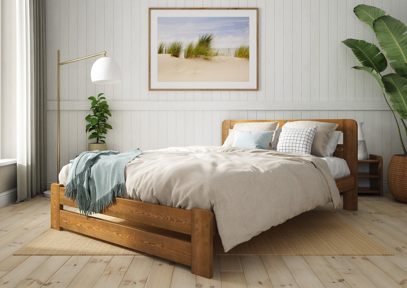 Wooden bed with grey bedding and a blue blanket in a bedroom setting