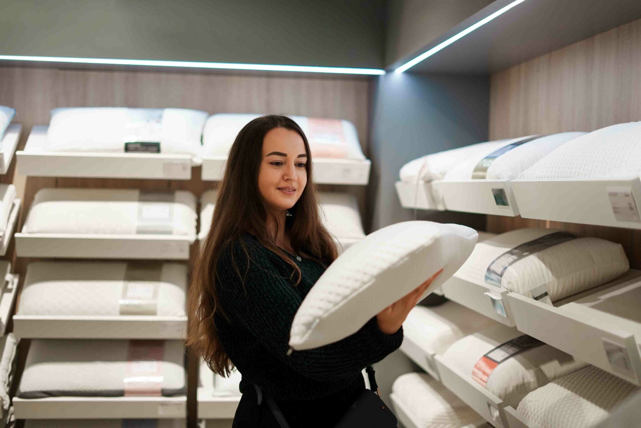 woman looking at a pillow in a shop