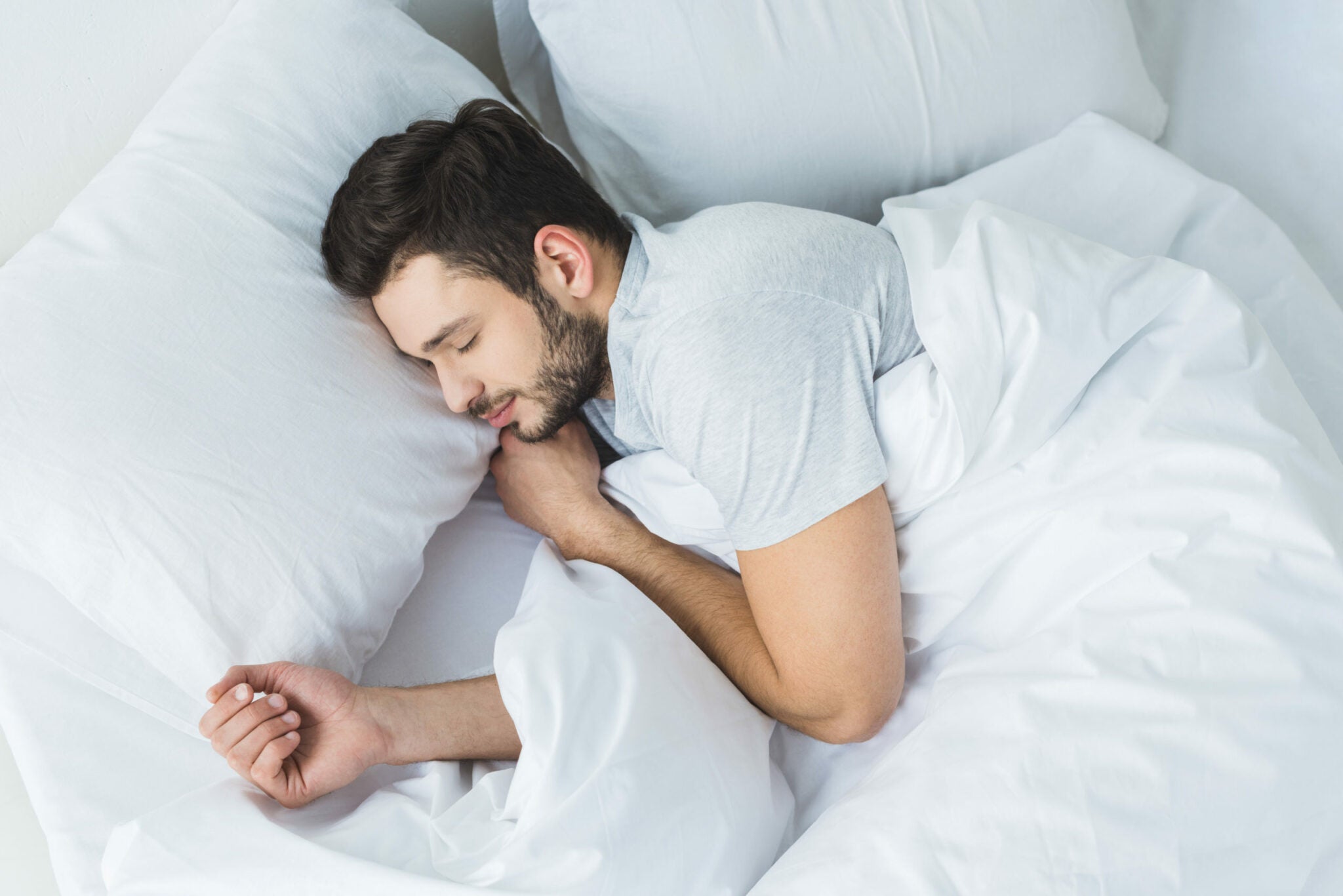 man sleeping on his side in bed