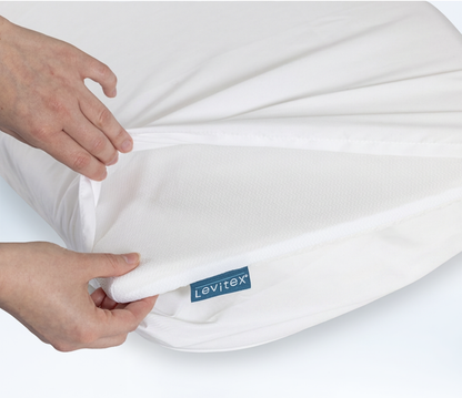Person opening up pillowcase to reveal Slice pillow topper on top of a regular old pillow