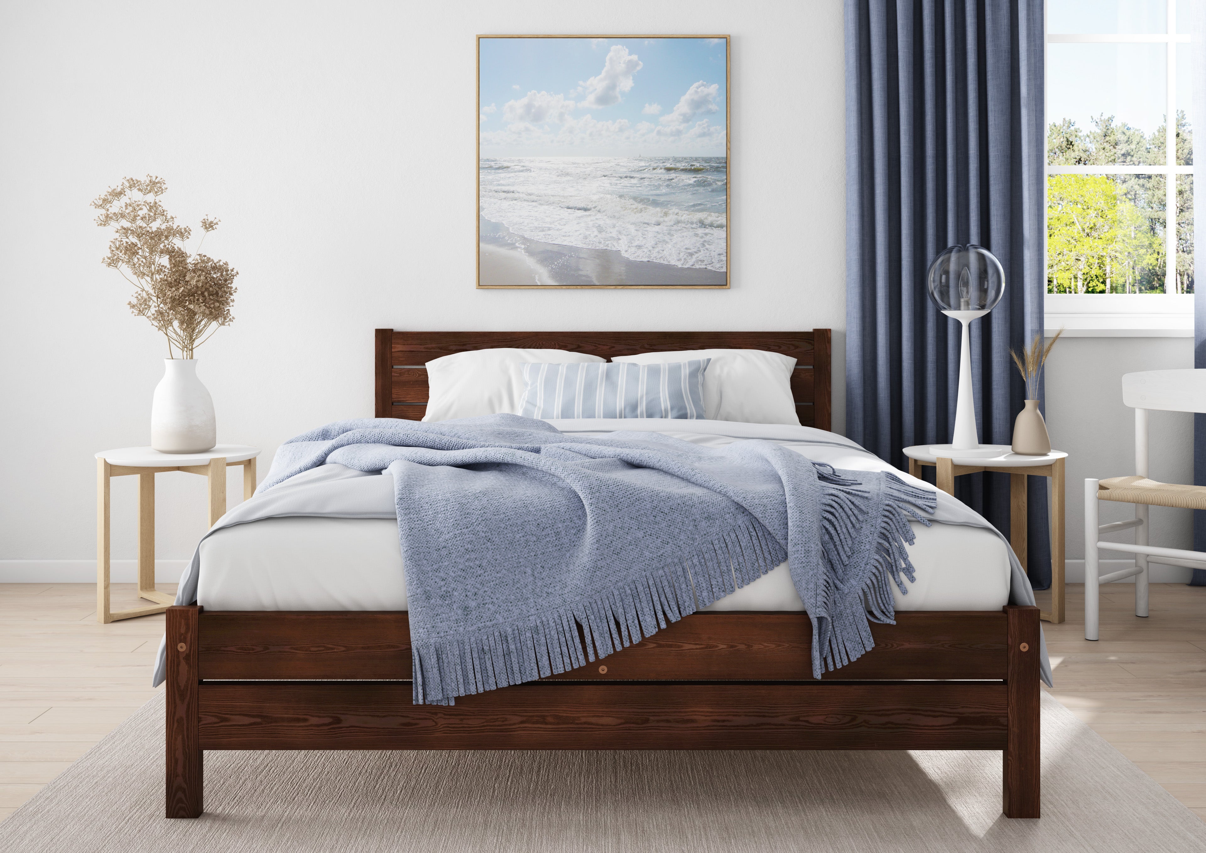 Wooden bed with white bedding and a blue blanket in a bedroom setting.