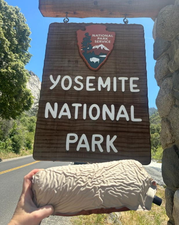 Rolled up travel pillow by the yosemite national park sign