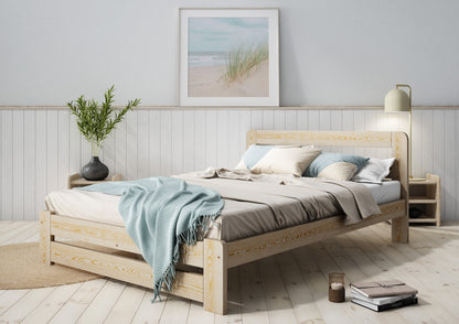 Wooden bed with grey bedding and a blue blanket in a bedroom setting
