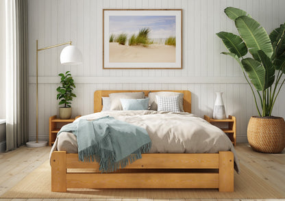 Wooden bed with grey bedding and a blue blanket in a bedroom setting