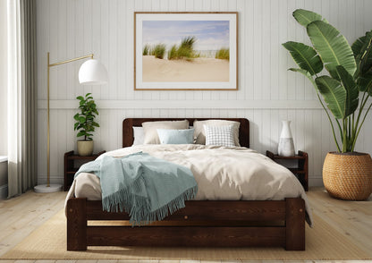 Wooden bed with grey bedding and a blue blanket in a bedroom setting