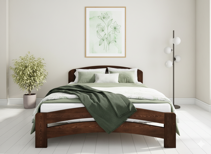 Wooden bed with green bedding in a bright bedroom setting
