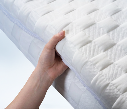 hand grabbing a white posture mattress topper