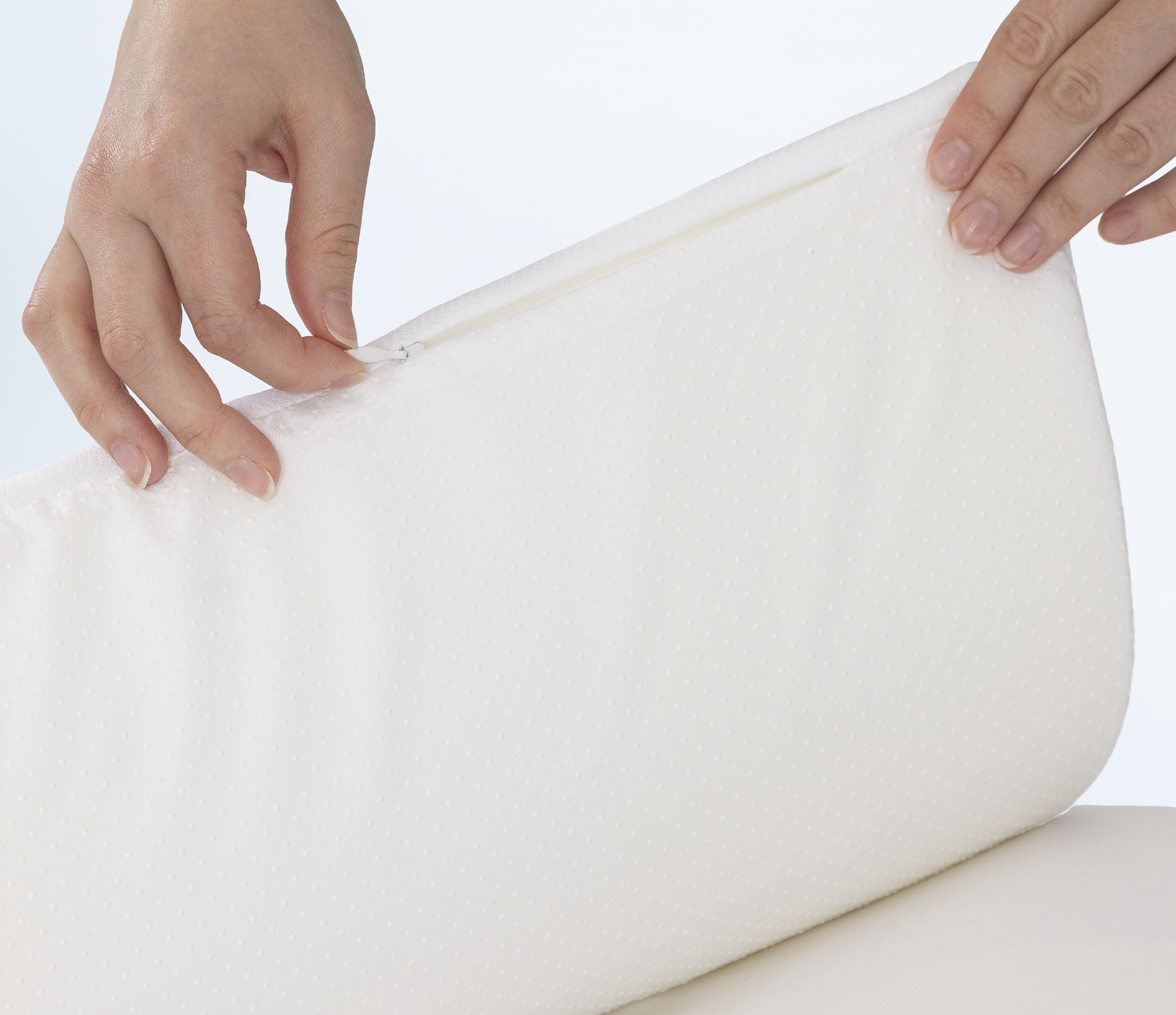 Close-up of a person holding a white pillow topper 