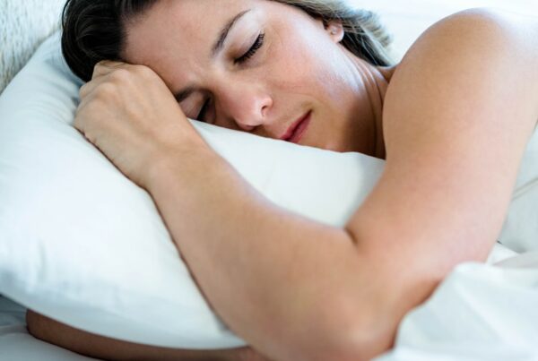 woman sleeping on her shoulder in bright bedding