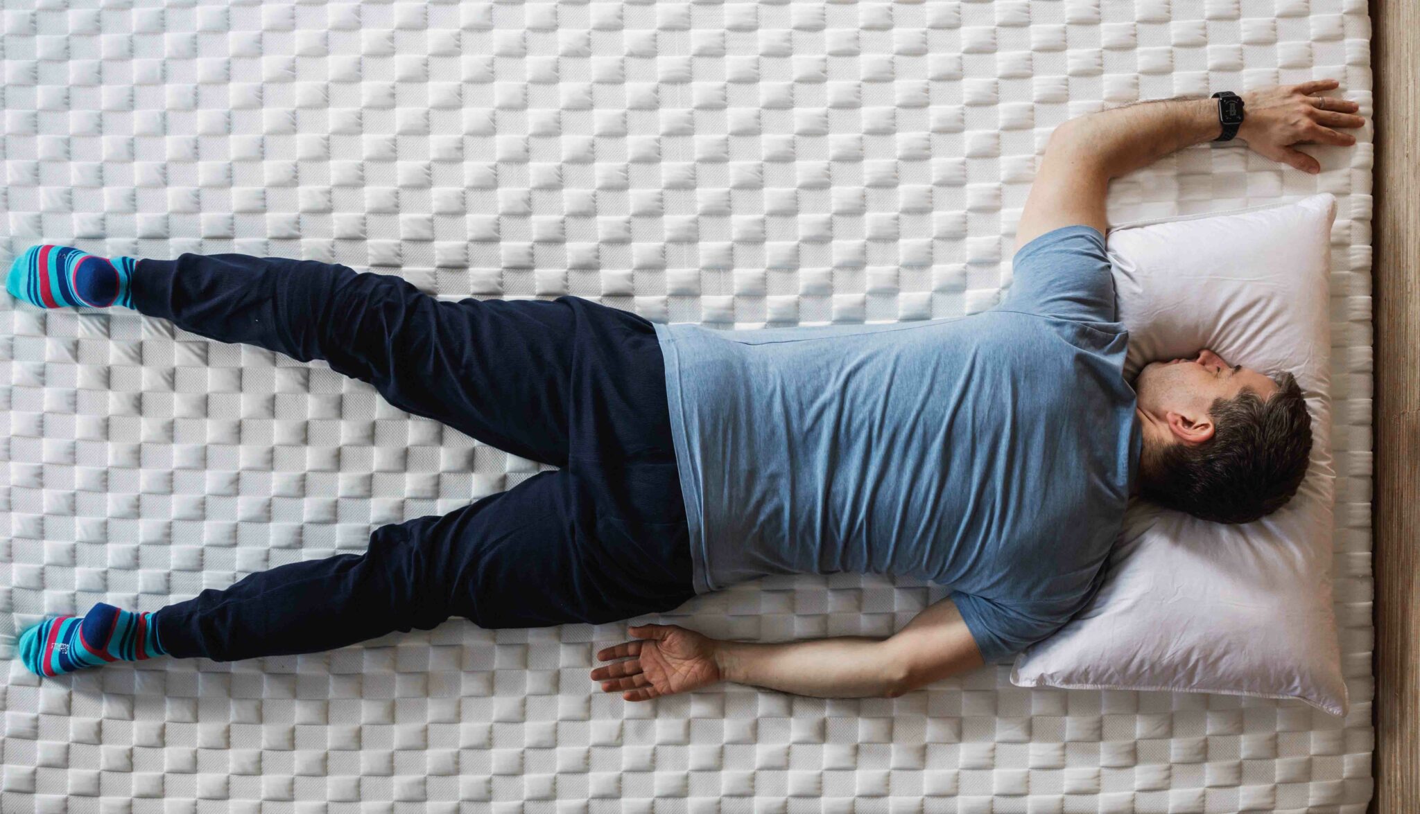 man lying on his front on a mattress