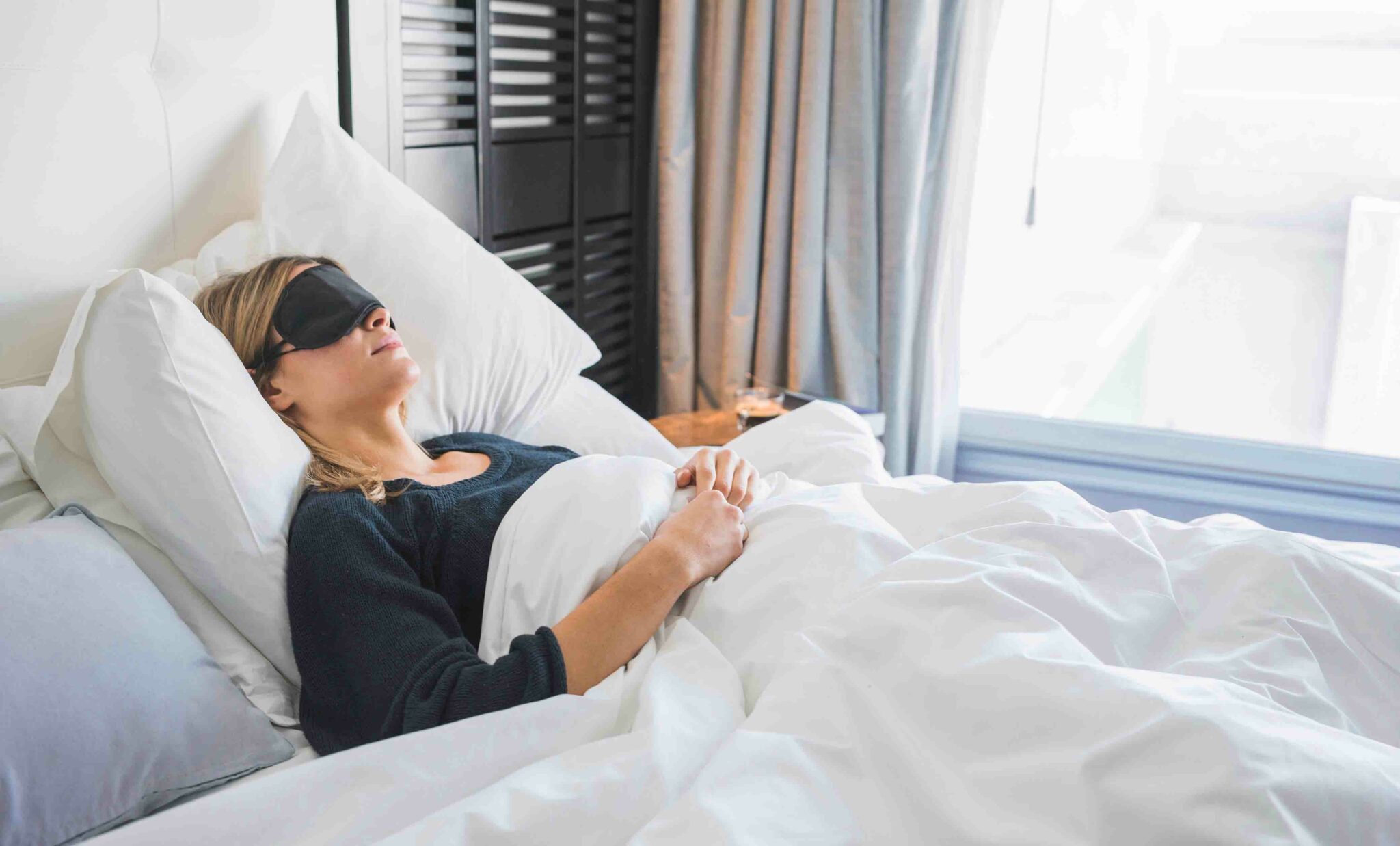 Woman sleeping on back with eye mask